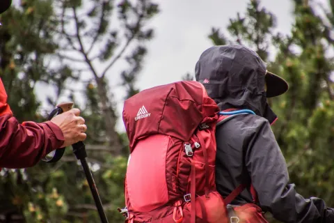 Wanderer mit rotem Tagesrucksack auf einer Bergtour