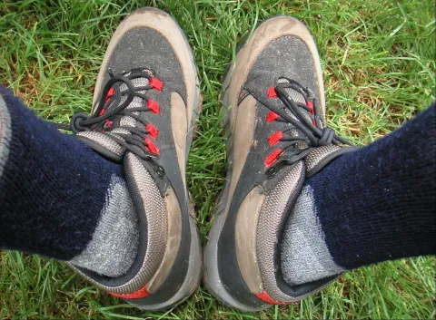 Wanderschuhe mit dicken Wandersocken auf einer Wiese